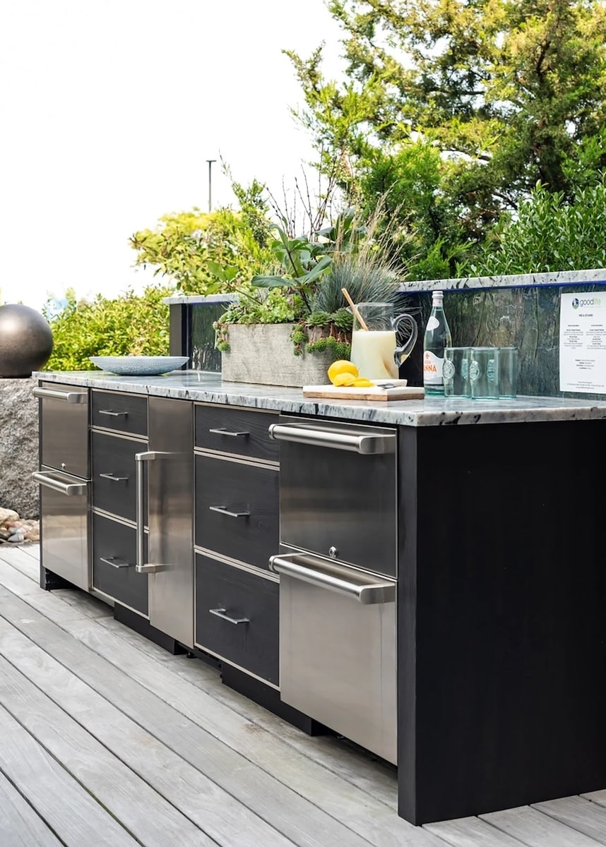 Outdoor kitchen with weatherproof woodgrain cabinetry and a built-in grill